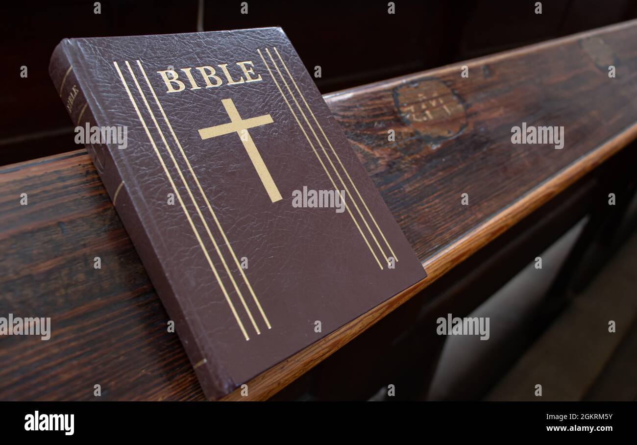 La Sacra Bibbia sulla tavola di un banco di preghiera nella chiesa, da vicino. Foto Stock