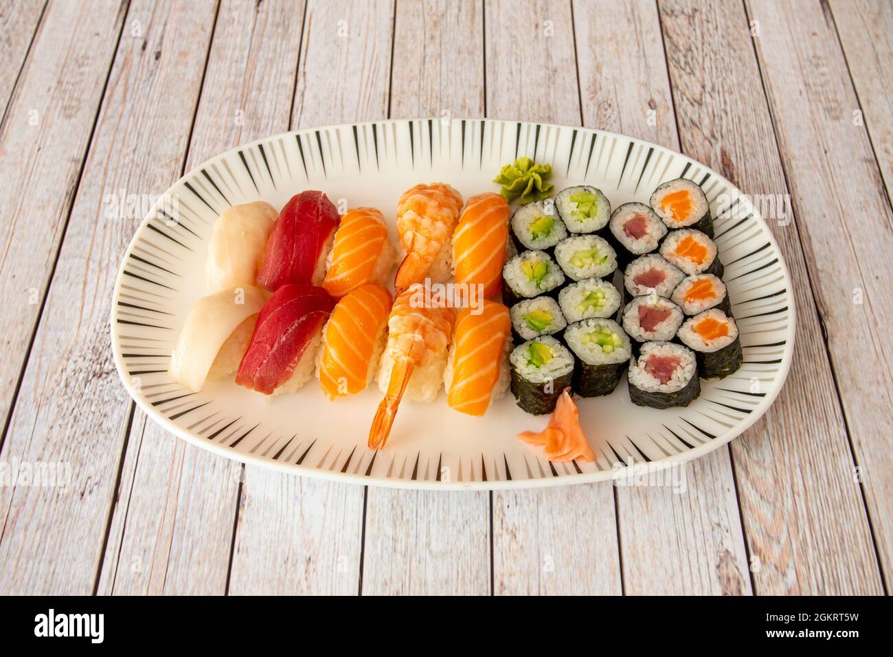 Vassoio di sushi nigiri assortiti e maki. Maki di tonno rosso e salmone con  zucchine, nigiri di tonno rosso, pesce farfalla, gamberi cotti e wasabi e  ginseng Foto stock - Alamy