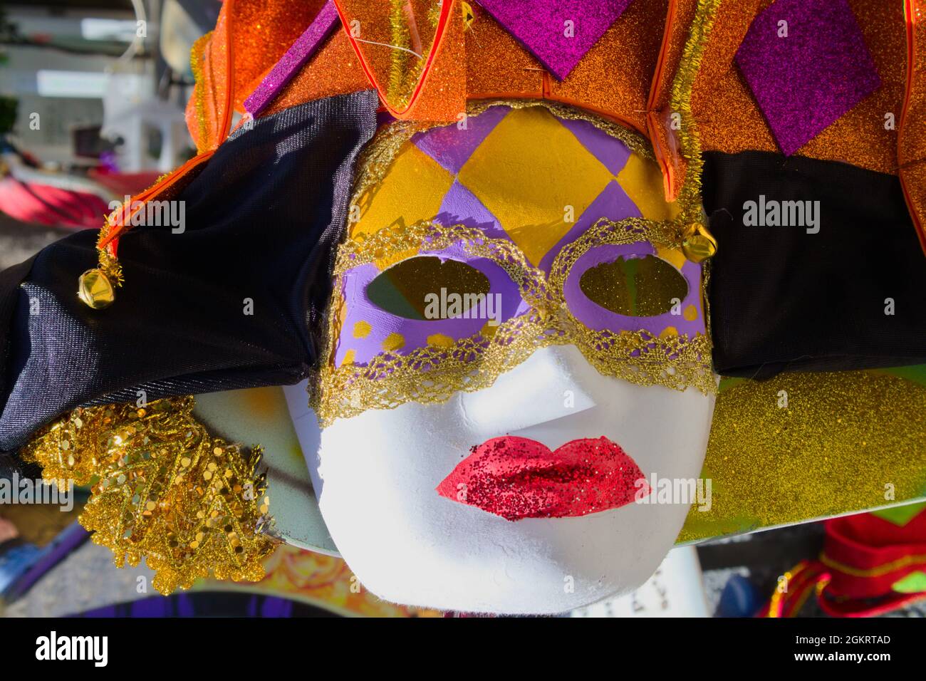 Immagine di una maschera decorata con colori vivaci nello stile del carnevale veneziano che è illuminato dal sole Foto Stock