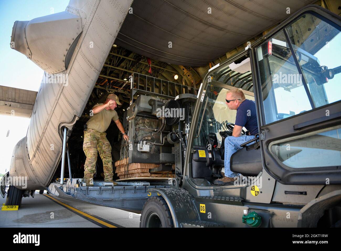 Personale Sgt. Ryan Haynes, un 757th Airlift Squadron loadmaster, dirige un Wright-Patterson Air Force base operatore di carrelli elevatori a forche nel scaricare un pacchetto di container Delivery System su un carrello elevatore a WPAPB, Ohio, 24 giugno 2021. Il pacchetto CDS è stato preparato dai membri della 76a Aerial Port Squadron della stazione di Youngstown Air Reserve Station e trasportato a WPADB a bordo di un 910th Airlift Wing C-130H Hercules aereo per l'uso in una missione di buona volontà mostra il Museo Nazionale dell'Aeronautica militare è in via di sviluppo. Foto Stock