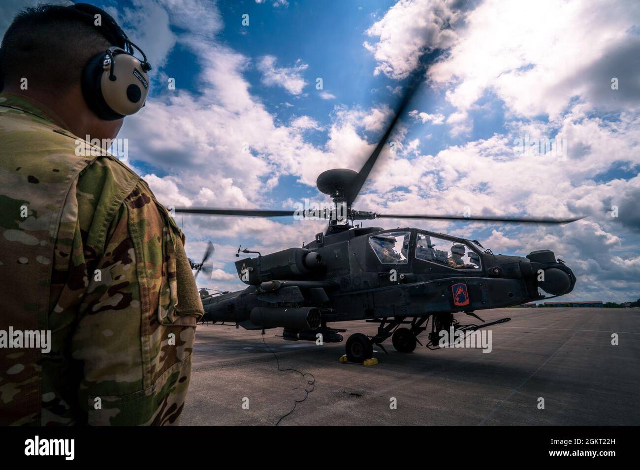 SPC dell'esercito degli Stati Uniti. Zaujun Aung Lahpai, un capo equipaggio AH-64, comunica con il Colon. John Broam, comandante della dodicesima brigata dell'aviazione da combattimento, e il Chief Warrant Officer 5 Robert Slider, attraverso i controlli finali pre-lancio presso l'aeroporto dell'esercito di Katterbach per il volo finale del Colon. Broam come aviatore dell'esercito il 24 giugno 2021. Foto Stock