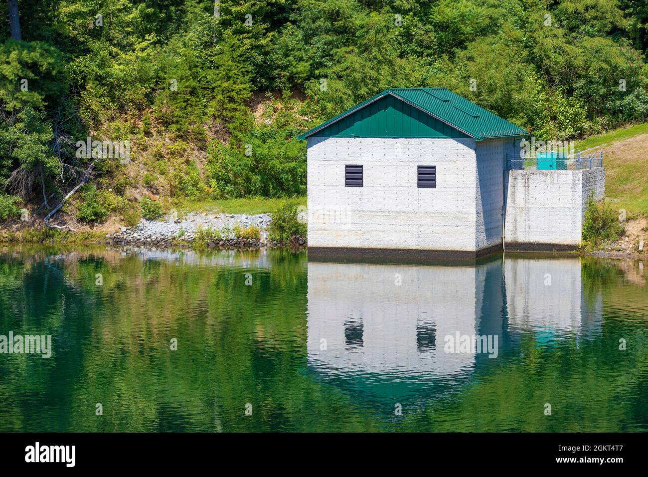 Un edificio di utilità si trova sulle rive del fiume Watauga che si riflette nelle acque delle vongole. Foto Stock