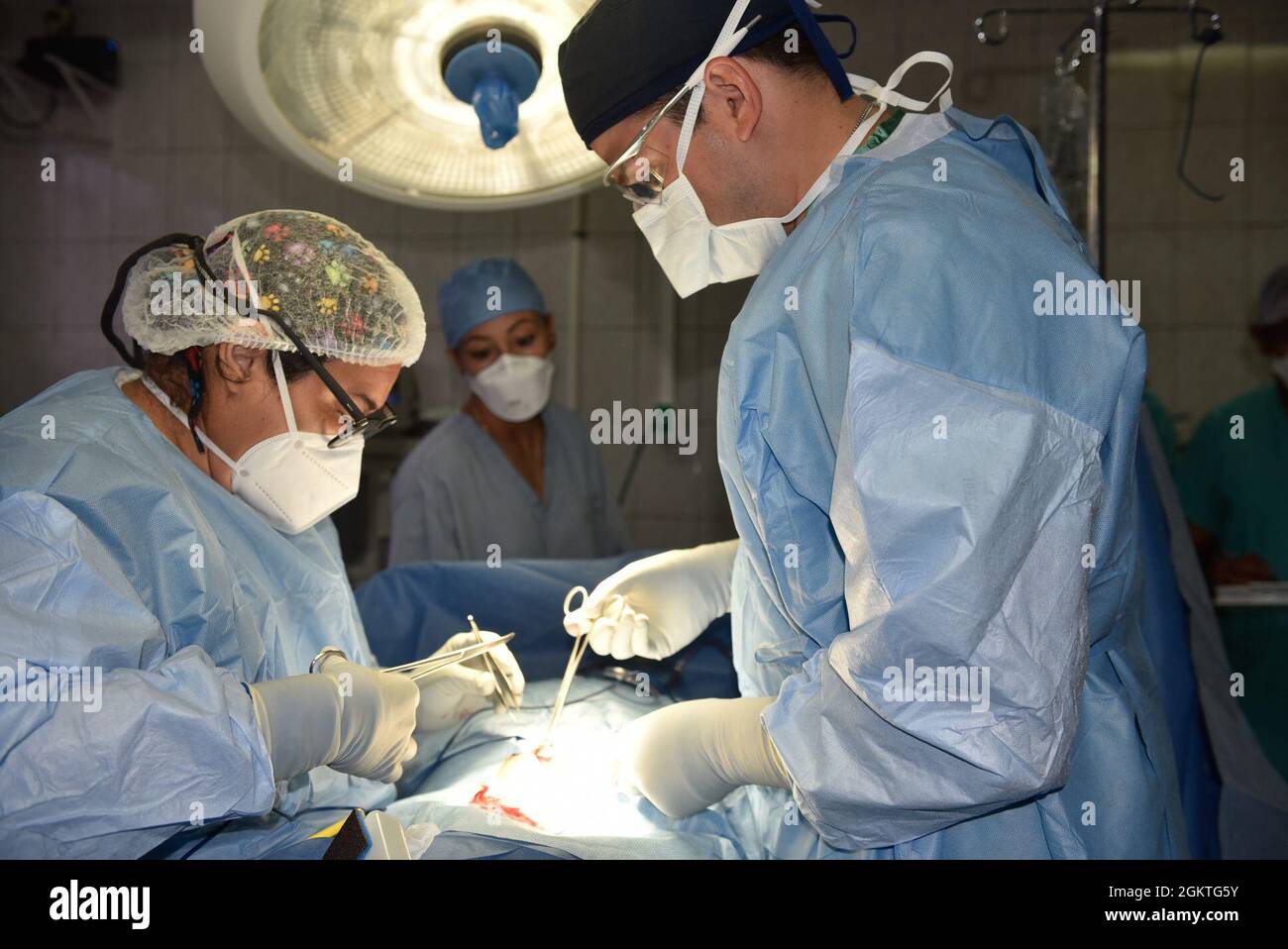 Il maggiore dell'esercito degli Stati Uniti Andrew Isaacson, un chirurgo con la Sezione chirurgica in avanti presso l'elemento medico, Joint Task Force-Bravo, Soto Cano Air base, Honduras, e un medico hondurano completare una rimozione della colecisti durante un impegno di salute globale nel dipartimento di Colón, 30 giugno 2021. In totale sono stati osservati 682 pazienti, 12 interventi chirurgici sono stati eseguiti e 499 bovini sono stati trattati con vaccini. Foto Stock