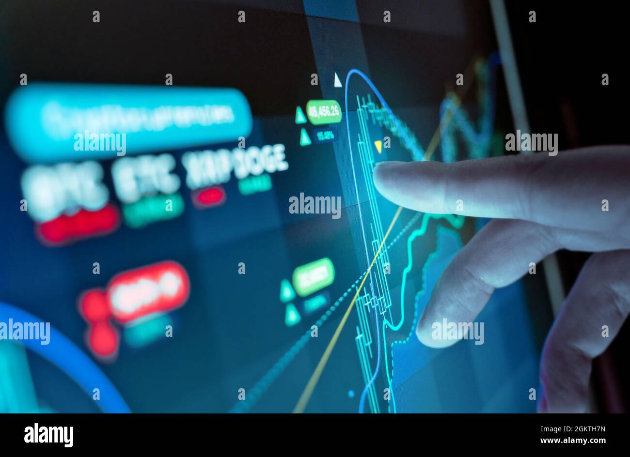 Un uomo che analizza i grafici dei prezzi della valuta virtuale su uno schermo, fondo di investimento di criptocurrency. Foto Stock