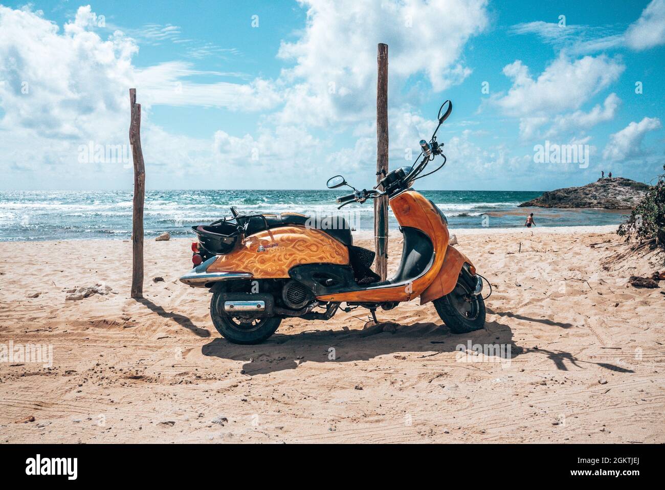 Scooter dal design giallo parcheggiato sulla spiaggia in una giornata di sole Foto Stock