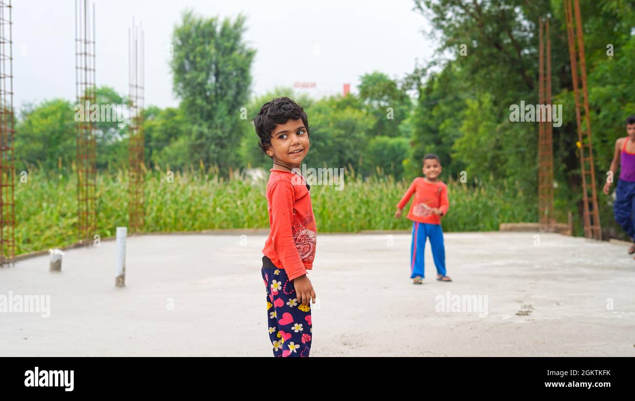 13 settembre 2021 Reengus, Rajasthan, India. Fuoco su ragazza con capelli neri in piedi e posando su terreno concreto. Vista frontale. Infanzia e creatività c Foto Stock