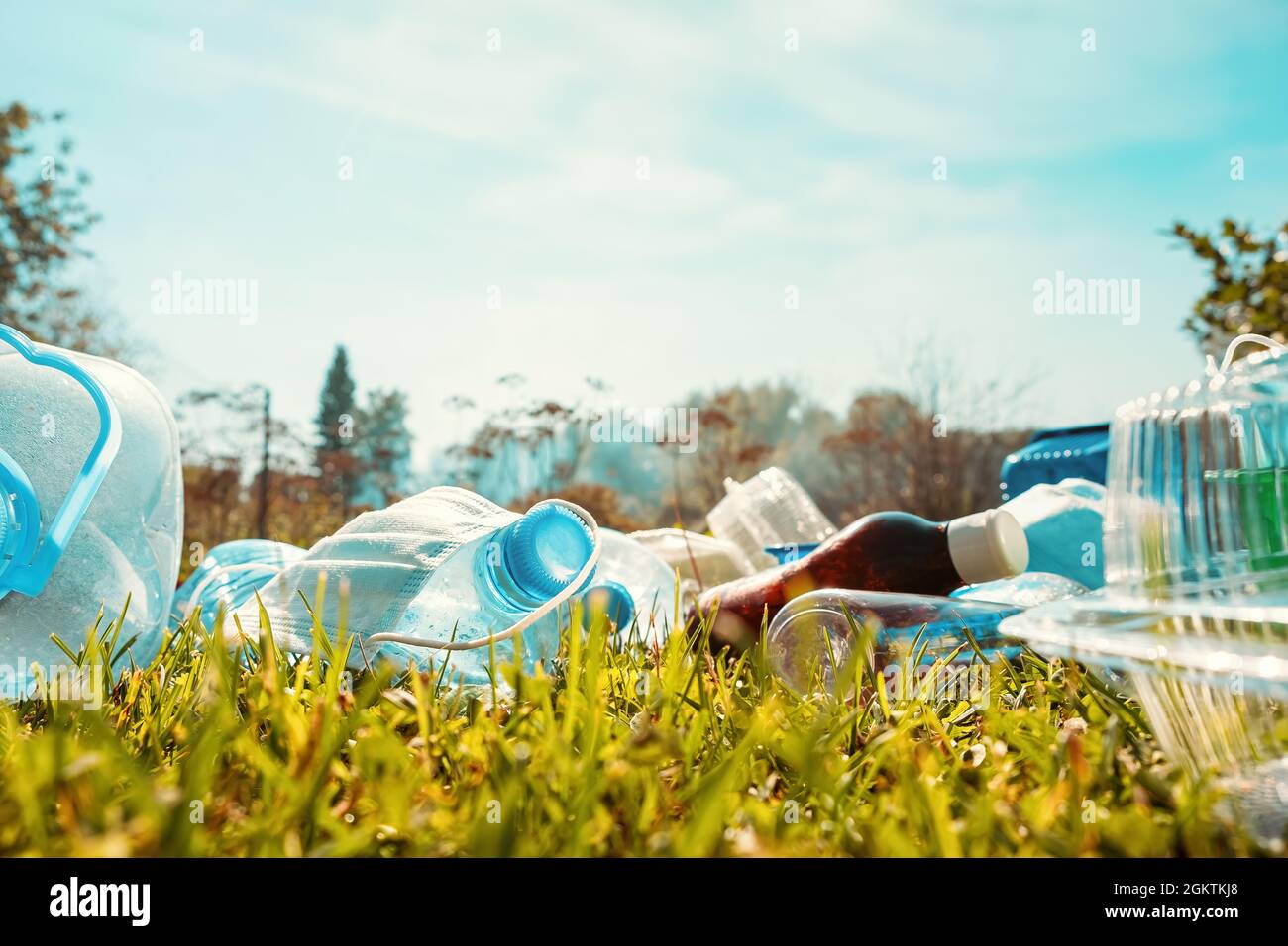 Primo piano spazzatura. Molti rifiuti di plastica si trovano nel parco sull'erba. Rifiuti di plastica su erba verde. Concetto ESG, SDG ed Ecologia. Riciclabile Foto Stock