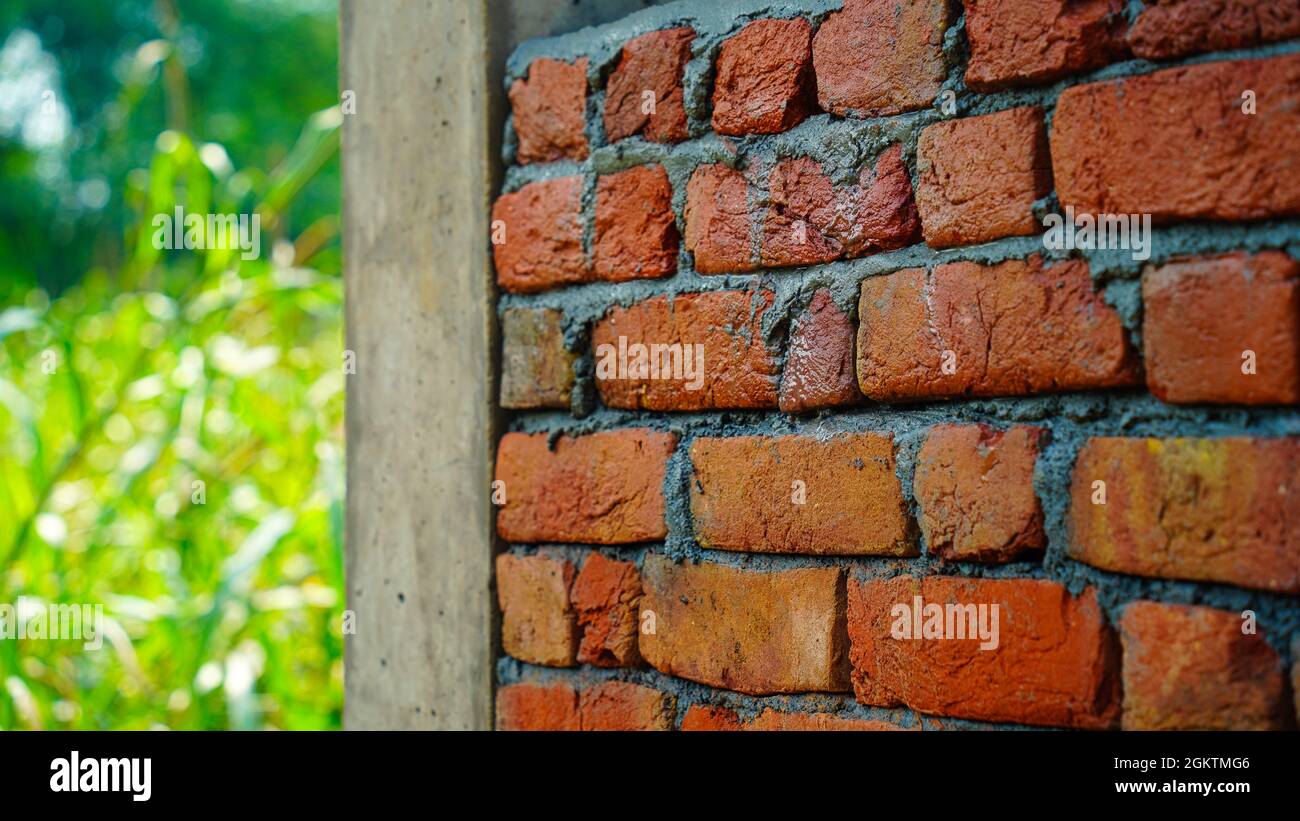 Muro di mattoni appena fatto con il mortaio di cemento, sabbia e acqua, fuoco selettivo Foto Stock