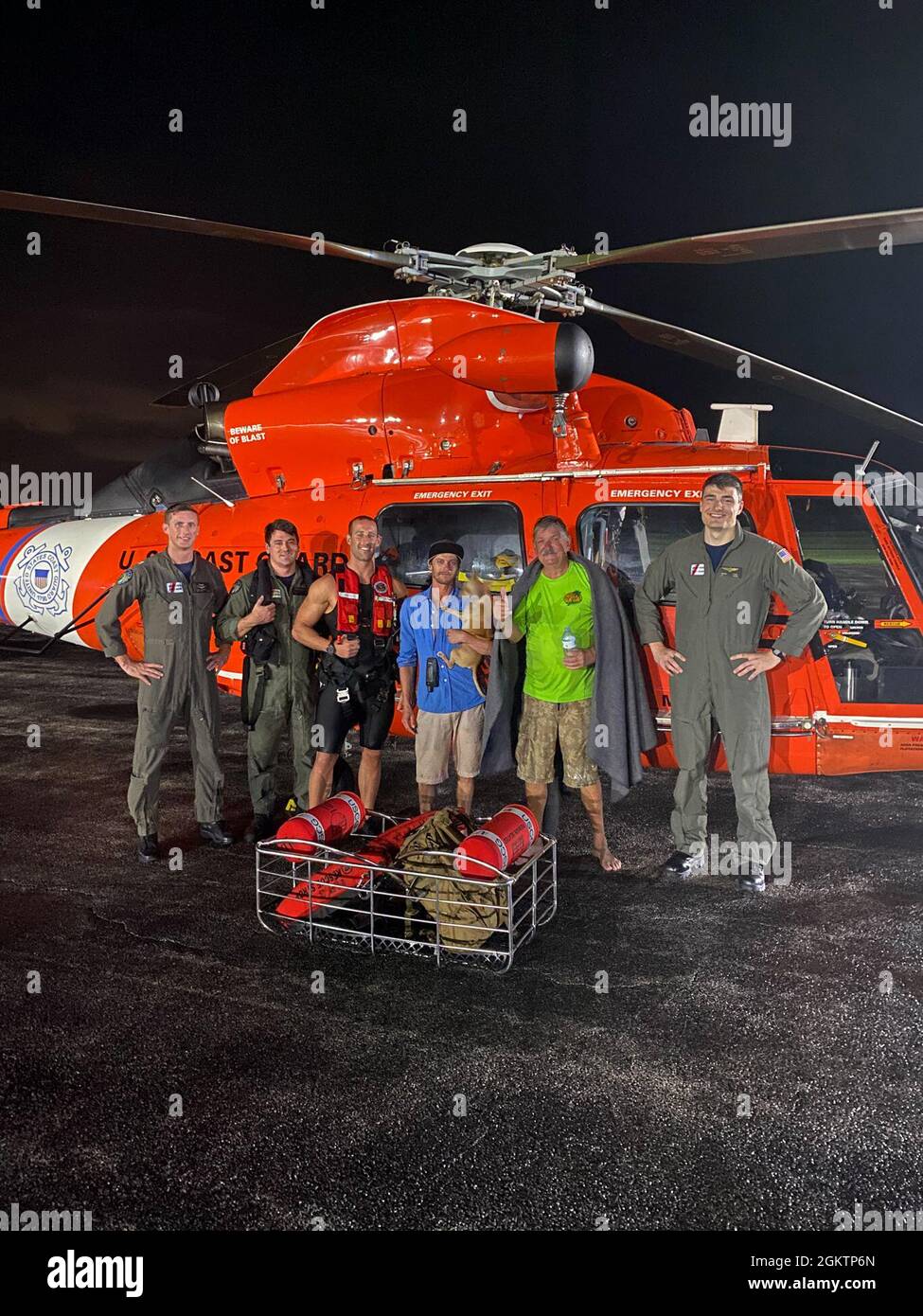 Air Station Miami equipaggio sono con le due persone salvate e il loro cane al Martin County Airport a Stuart, Florida 30 giugno 2021. L'equipaggio ha issato le due persone e il loro cane da una zattera dopo che la loro nave affondò vicino a Jensen Beach, Florida. Foto Stock