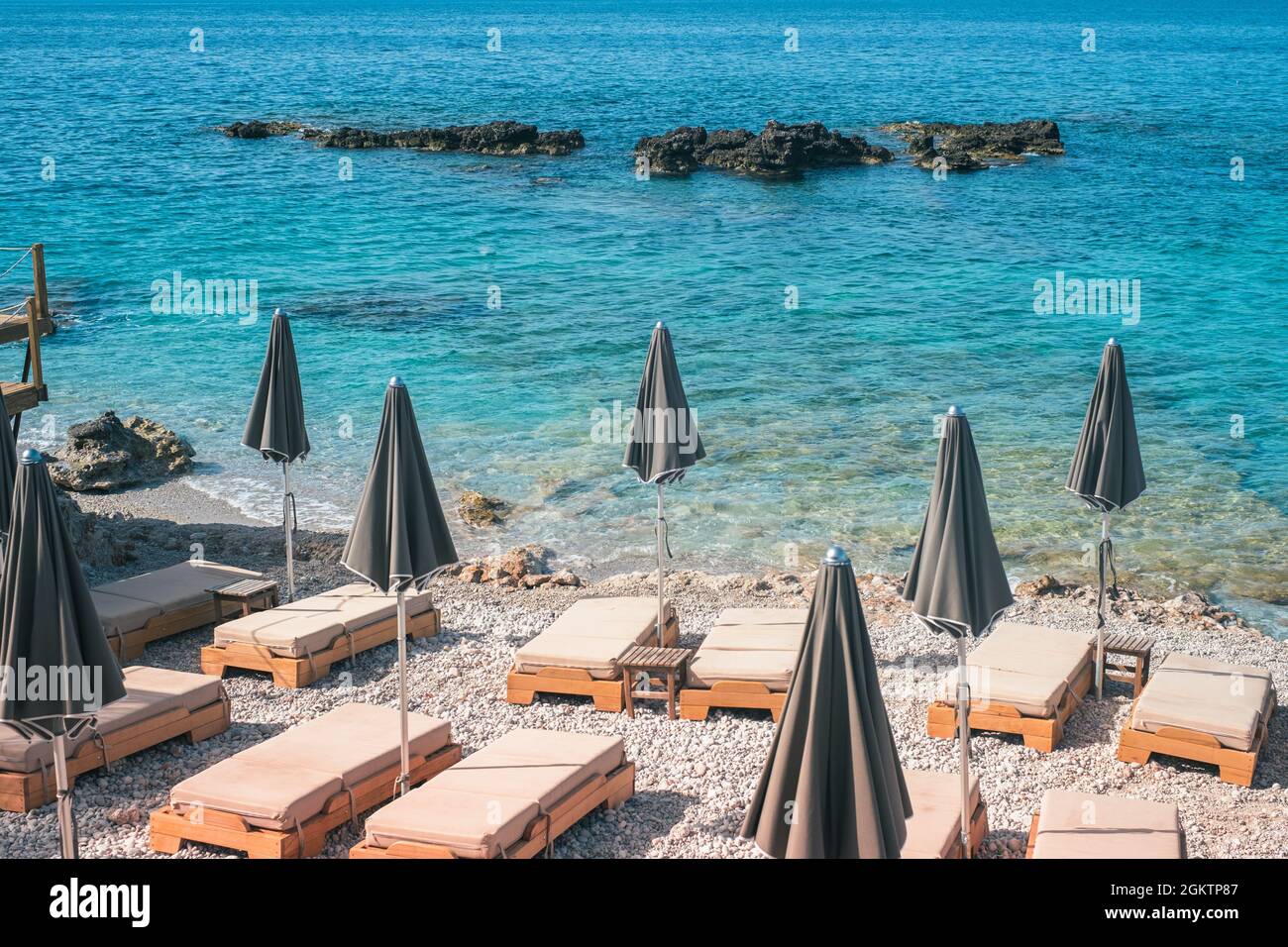 Vista tranquilla sulla spiaggia di Dhermi acque turchesi e ombrelloni Albania Foto Stock
