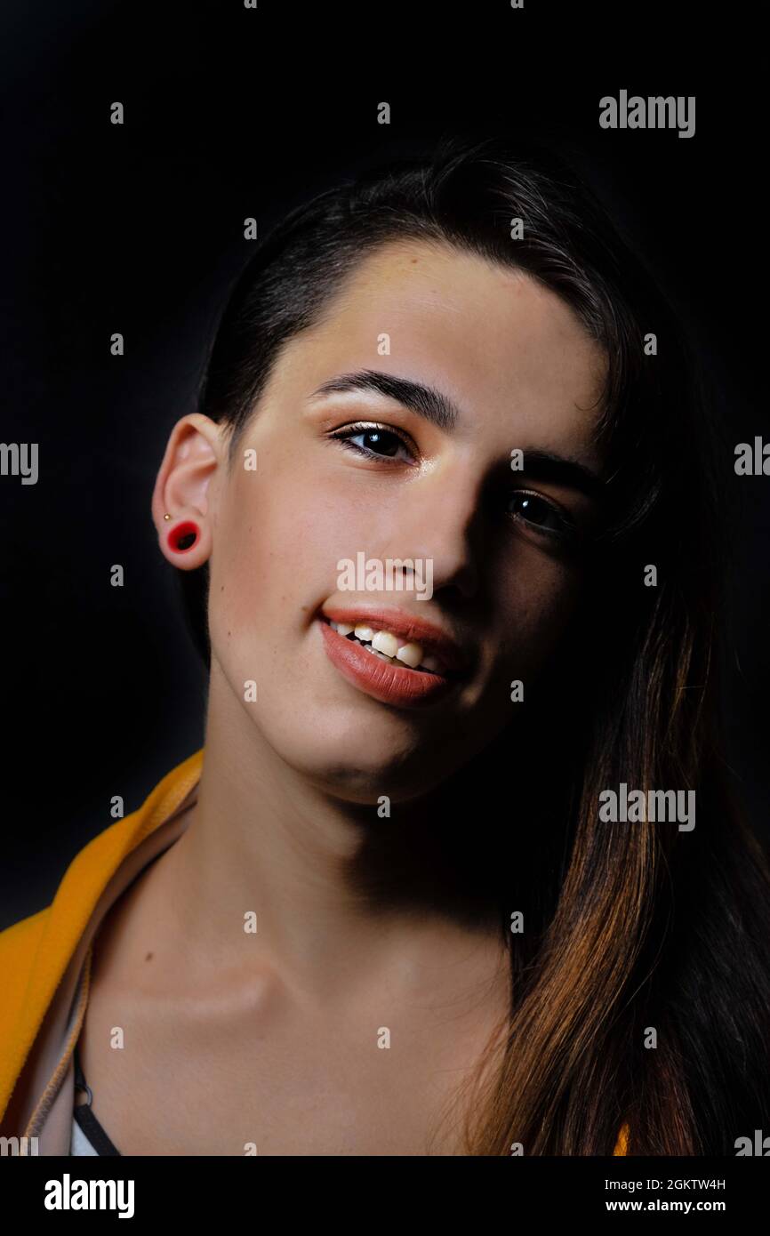 Giovane bella donna ispanica transgender su sfondo nero Foto Stock