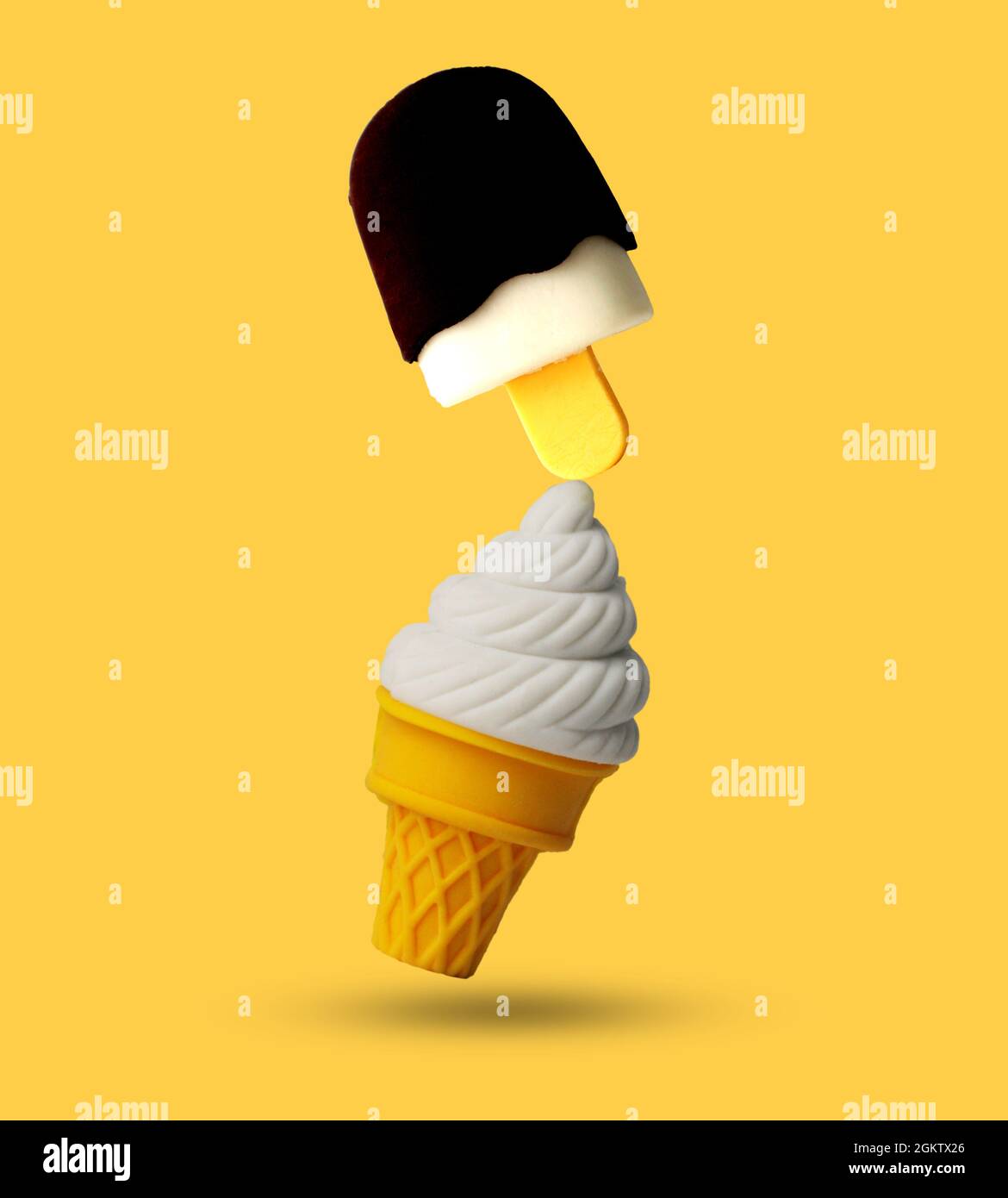 Layout creativo composto da una tazza per gelato e un bastone equilibrati su sfondo giallo. Concetto minimo di cibo estivo. Foto Stock