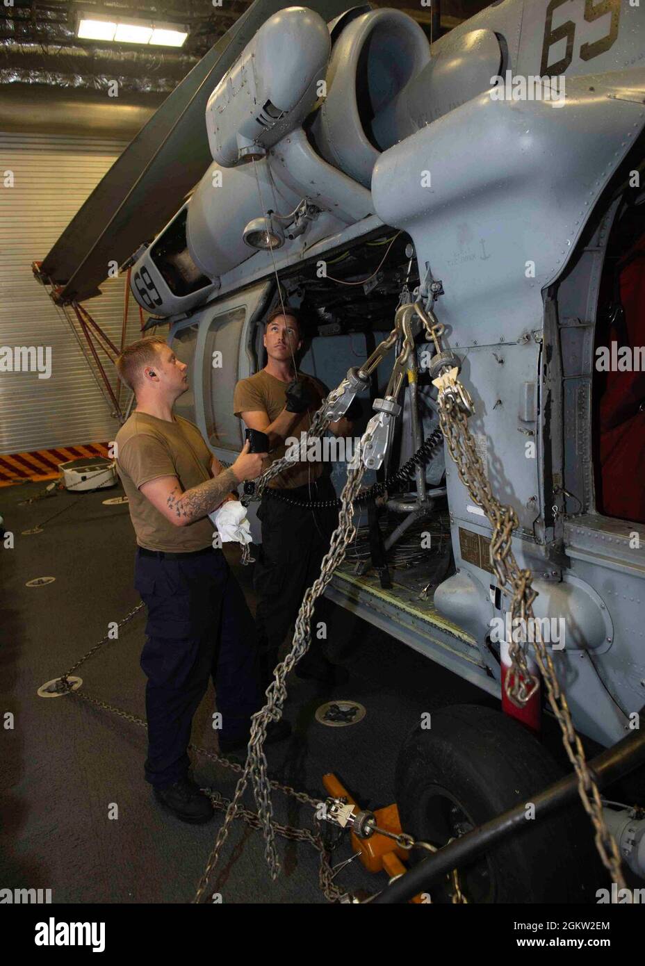 PHILIPPINE SEA (3 luglio 2021) Aviation Structural Mechanic 2nd Class Jerick Ireland, from Osborne, Idaho, left, E Aviation Electrician’s Mate 3rd Class Garrett Cates, di Irvine, California, entrambi assegnati a Helicopter Sea Combat Squadron 21 (HSC 21) eseguono la manutenzione su un elicottero MH-60 Sea Hawk mentre sono in corso sulla nave da combattimento litoranea variante indipendente USS Tulsa (LCS 16) il 3 luglio 2021. Tulsa, parte di Destroyer Squadron Seven, è su uno schieramento rotazionale, che opera nell'area operativa della 7a flotta degli Stati Uniti per migliorare l'interoperabilità con i partner e servire come pronto-risposta fo Foto Stock