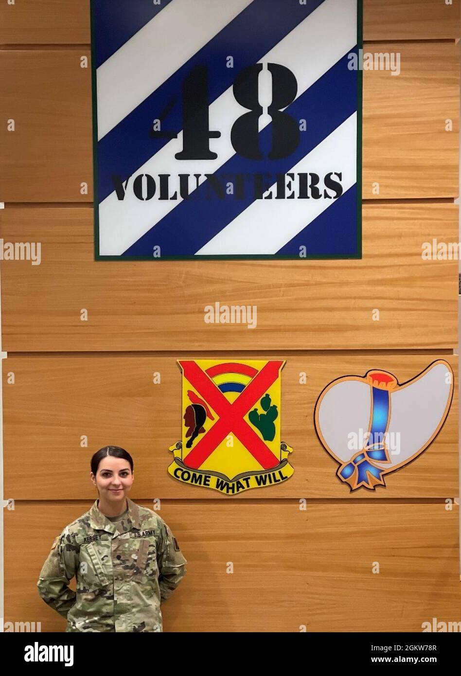 SPC. Gabrielle Kersey si pone di fronte alle insegne della 48a squadra di combattimento di fanteria Brigade presso la 48a sede centrale IBCT a Macon, GA, 1 luglio 2021. Foto Stock