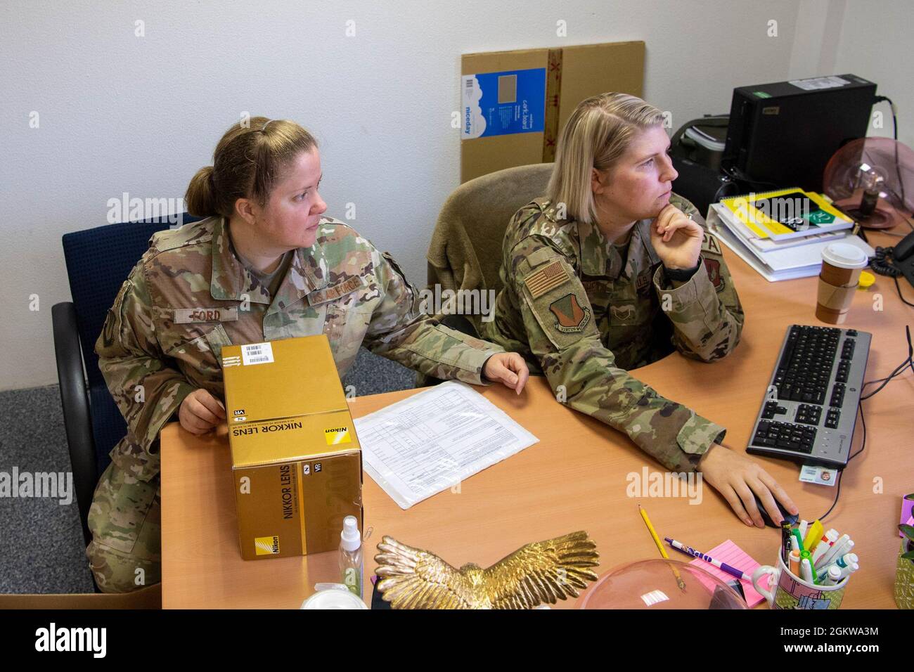 U.S. Air Force Tech. SGT. Jocelyn Ford, 86th Airlift Wing Public Affairs non commissionato ufficiale in carica di informazioni di comando, aiuta il personale Sgt. Leah Ritchey, 86th Airlift Wing Public Affairs Specialist, destra, prendere l'inventario alla base aerea di Ramstein, Germania, 8 luglio 2021. La pianificazione e la supervisione di Ford guidano gli sforzi di comunicazione su tutte le piattaforme di PA, tra cui il sito web di base, i social media e il giornale di base. Foto Stock