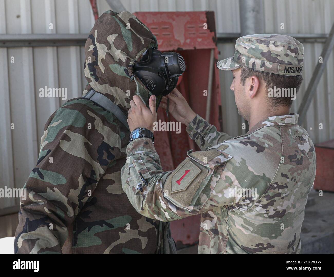 Amar Misimovic assiste il PFC dell'esercito degli Stati Uniti. Dylan Vickers nel mettere sul suo MOPP 4 abbigliamento protettivo alla Mihail Kogalniceanu Air base in Romania, 9 luglio 2021. MOPP 4 è composto da una maschera protettiva, un supporto per maschera e un cappotto JSLIST, pantaloni, guanti e stivali. Lo spiegamento di forze americane pronte e credibili nei combattimenti in Europa a sostegno della risolutezza atlantica è la prova del forte e inremotabile impegno degli Stati Uniti nei confronti della NATO e dell'Europa. Foto Stock