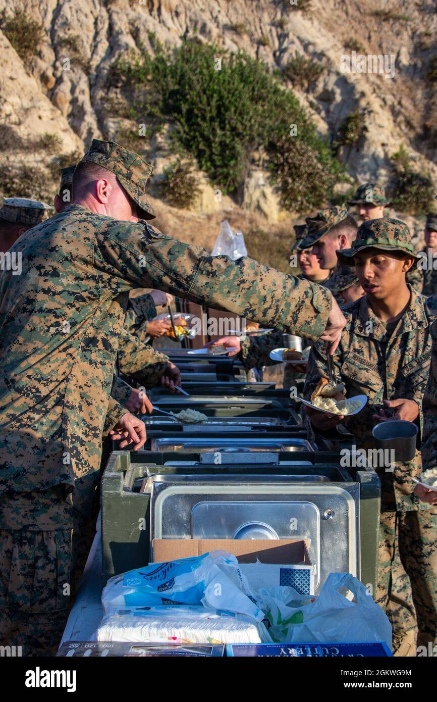 I Marines degli Stati Uniti con la sede centrale e la sede centrale Squadron, il campo della stazione aerea del corpo della Marina di Pendleton, servono il cibo durante una notte del guerriero a Red Beach sul campo della base del corpo della Marina di Pendleton, California, 9 luglio 2021. La Notte del Guerriero fu tenuta per costruire la camerateria e l'esprit de Corps all'interno dello squadrone. Foto Stock