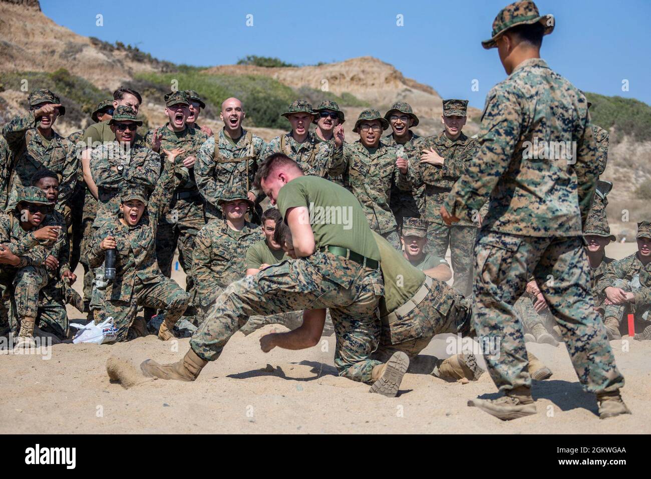 CPL. Marino USA Jacob Johnson, un controllore del traffico aereo con quartier generale e quartier generale Squadron, Marine Corps Air Station Camp Pendlton, mette una Marina in un headlock durante una Notte dei Guerrieri a Red Beach sul Marine Corps base Camp Pendleton, California, 9 luglio 2021. La Notte del Guerriero fu tenuta per costruire la camerateria e l'esprit de Corps all'interno dello squadrone. Johnson è un nativo di Mesa, Arizona. Foto Stock