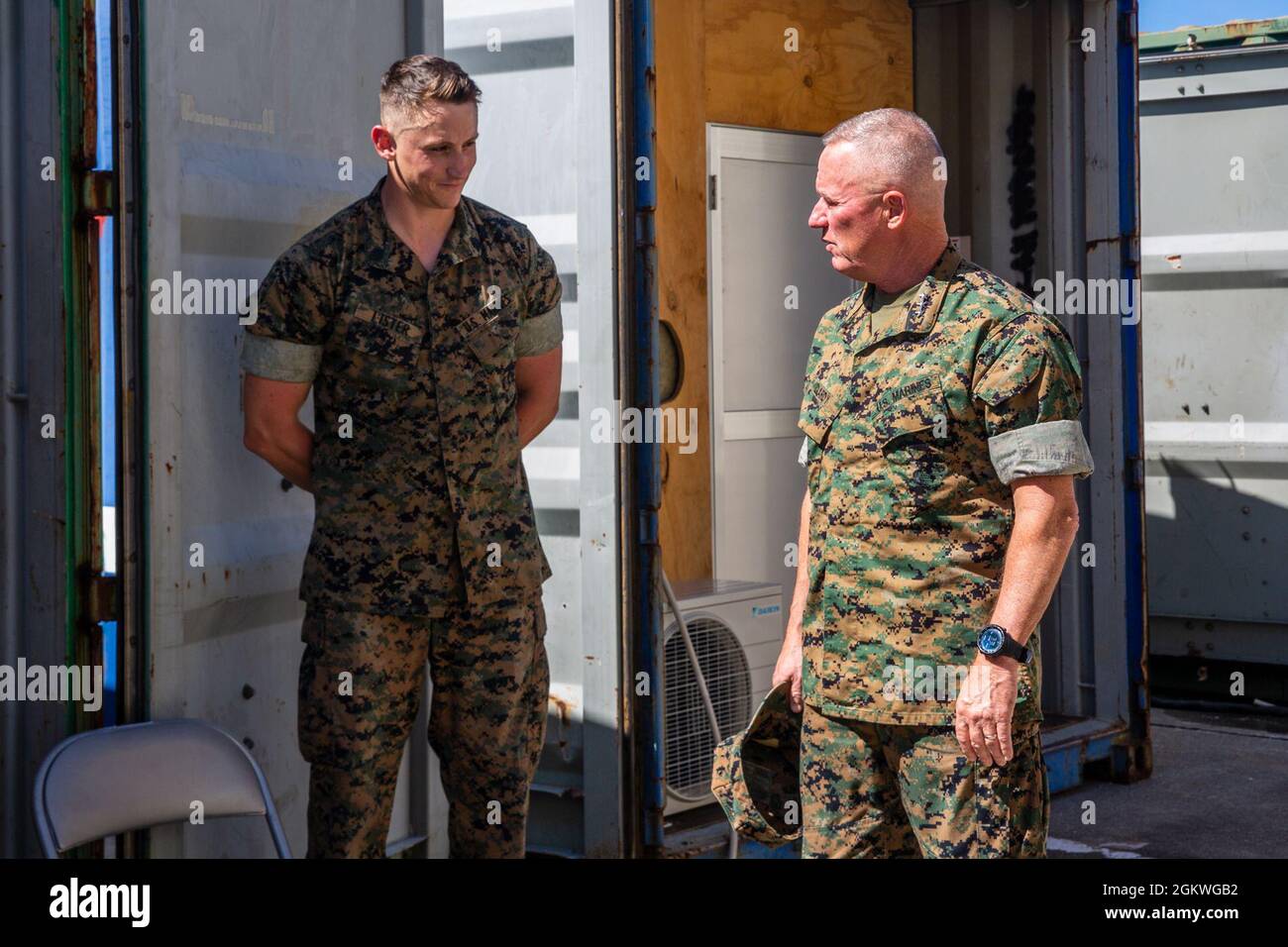 Stacy Clarcy, comandante generale, III forza di spedizione marina, converge con il personale Sgt. Charles Lister, capo del team con la 5a Air Naval Gunfire Liaison Company, III MEF Information Group, a Camp Hansen, Okinawa, Giappone, 9 luglio, 2021. III MIG ha presentato le sue capacità e come prevede di implementare il suo concetto di combattimento a sostegno del III MEF durante la visita del comandante MARFORPAC. Foto Stock