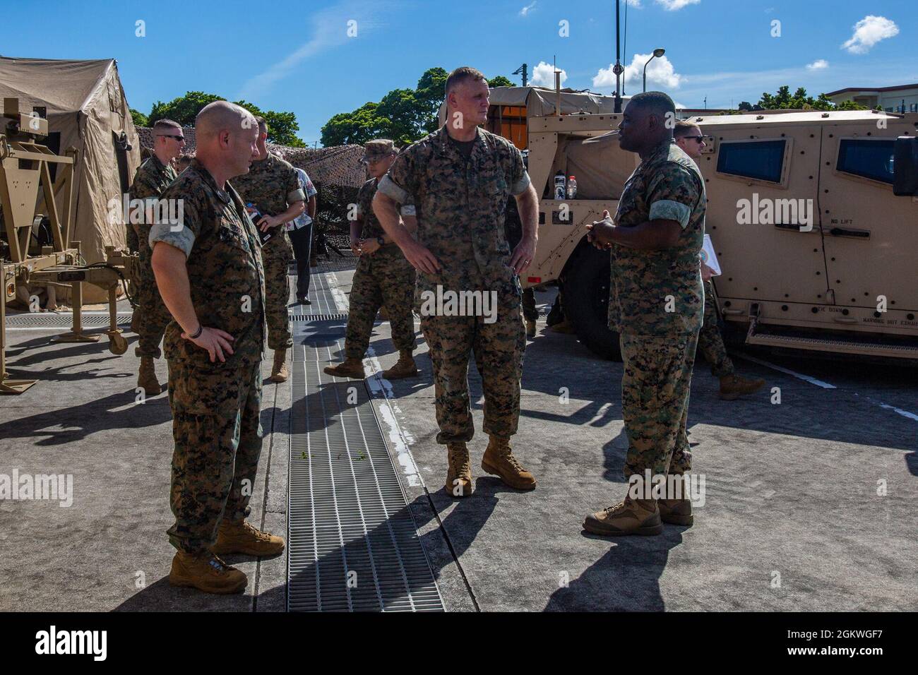 Rudder (centro), comandante, forze del corpo marino degli Stati Uniti, Pacifico, e il colon. Lester Gerber (sinistra), comandante, III Marine Expeditionary Force Information Group, parlano con il sig. Andrew Holmes, una marina con III MIG, a Camp Hansen, Okinawa, Giappone, 9 luglio, 2021. III MIG ha presentato le sue capacità e come prevede di implementare il suo concetto di combattimento a sostegno del III MEF durante la visita del comandante MARFORPAC. Foto Stock
