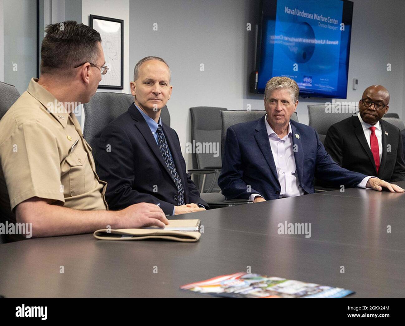 Naval Undersea Warfare Center Division Newport Commanding Officer Capt. Chad Hennings (da sinistra) e Direttore tecnico Ron Vien, parlano con Rhode Island Gov. DaN McKee e il pastore Chris Abhulime, vice capo dello staff del governatore, sulla missione di Division Newport e sui contributi economici durante un briefing tenuto il 14 luglio 2021. Foto Stock