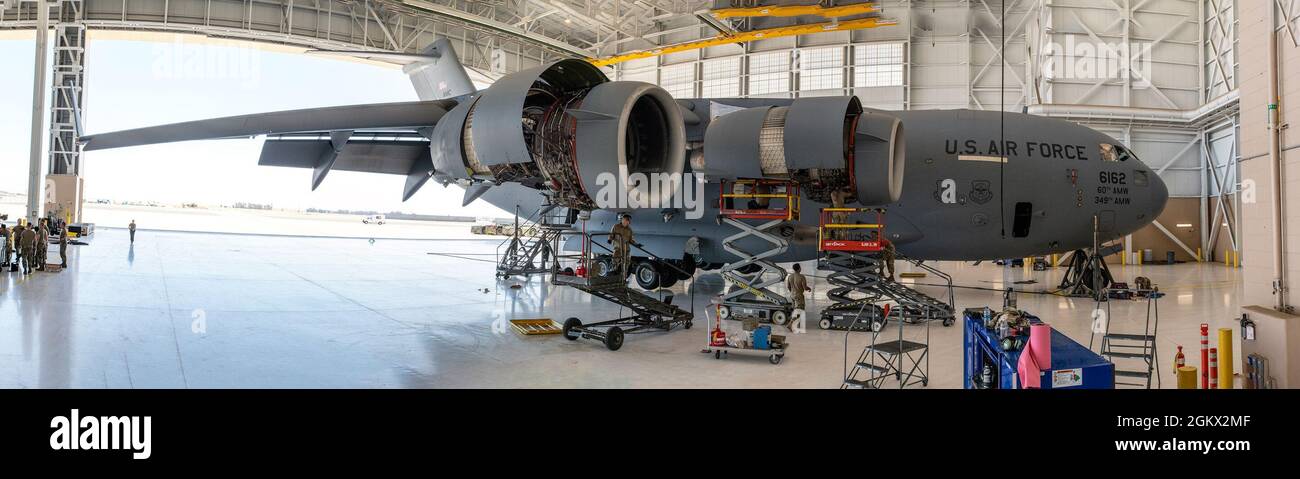 Gli airman assegnati al 860esimo Squadron di manutenzione dell'aeromobile, alla base dell'aeronautica di Travis, California, e al 105esimo Squadron di manutenzione, alla base della guardia nazionale dell'aria di Stewart, New York, lavorano insieme durante la manutenzione ordinaria del motore su un C-17 Globemaster III il 14 luglio 2021, a Travis AFB. Ogni motore C-17 è in grado di generare 40,440 libbre di spinta e include invertitori di spinta che dirigono il flusso d'aria verso l'alto e in avanti per evitare l'ingestione di polvere e detriti. Foto Stock