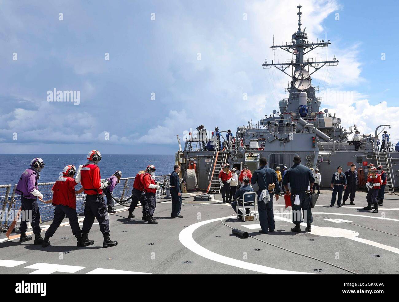 I marinai a bordo del cacciatorpediniere missilistico guidato di classe Arleigh Burke USS Benfold (DDG 65) combattono un incendio simulato durante un'esercitazione antincendio del ponte di volo. Benfold è assegnato al Comandante, Task Force (CTF) 71/Destroyer Squadron (DESRON) 15, il più grande DESRON dispiegato in avanti della Marina e la principale forza di superficie della 7a flotta statunitense. Foto Stock