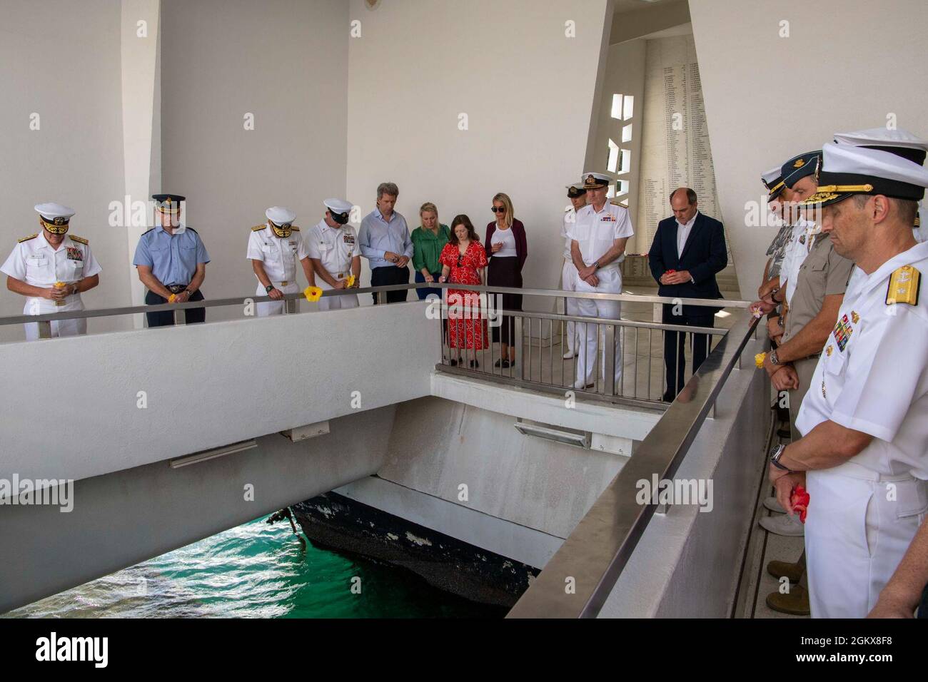 PEARL HARBOR, Hawaii (16 luglio 2021) (da sinistra) Comandante della U.S. Pacific Fleet ADM. Samuel Paparo, Capo del personale aereo del Regno Unito, il Maresciallo Mike Wigston, il Signore britannico del primo mare e il Capo del personale navale ADM. Tony Radakin, Segretario di Stato britannico per la Difesa ben Wallace, gli ospiti e il personale osservano un momento di silenzio prima di rilasciare petali di fiori per onorare i marinai caduti e i Marines della USS Arizona (BB-39) a bordo del USS Arizona Memorial. La visita dimostra l'importanza della partnership tra Regno Unito e Stati Uniti per la difesa e dell'interoperabilità tra partner internazionali di mentalità simile nell'Indo-Pa Foto Stock