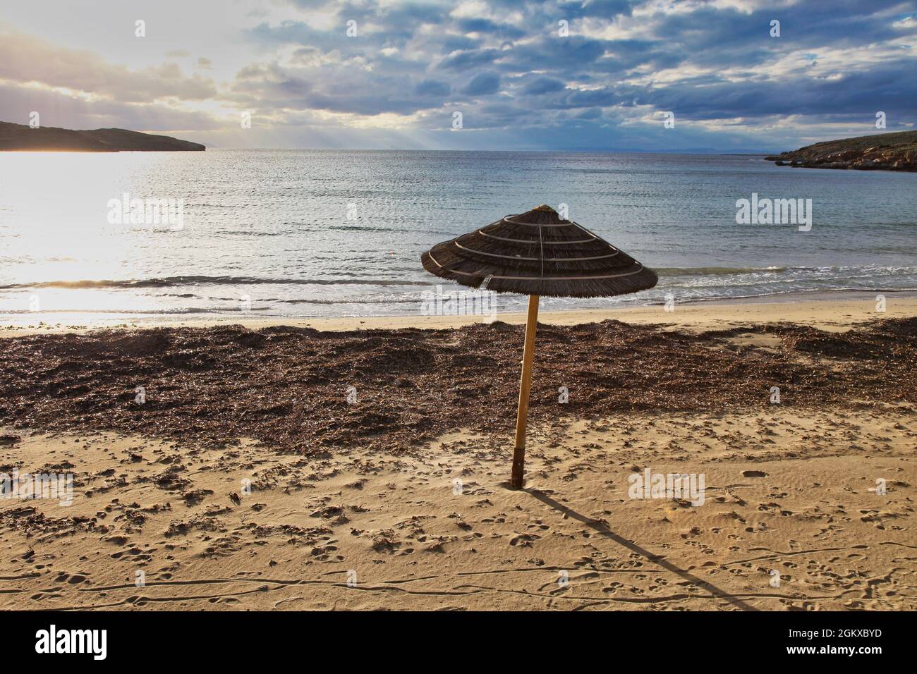 Ombrello sulla spiaggia. Ombrellone a paglia singola su una spiaggia  dell'isola di Syros in Grecia Foto stock - Alamy