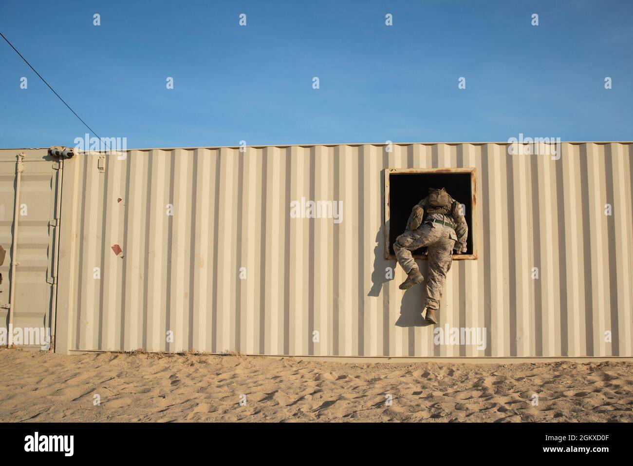 US Marine Corps Lance CPL. Jonathan Callejas, un fucile con Co. L, 3° Battaglione, 4° Reggimento Marino, 1° Divisione Marina, si arrampica in una finestra durante l'addestramento difensivo urbano al Marine Corps Air Ground Combat Center Twentynine Palms, California, 17 luglio 2021. Marines con il 7° Regiment Marino ha partecipato a vari esercizi di allenamento per competere per ‘miglior squadra’ in preparazione per Super Squad. Foto Stock