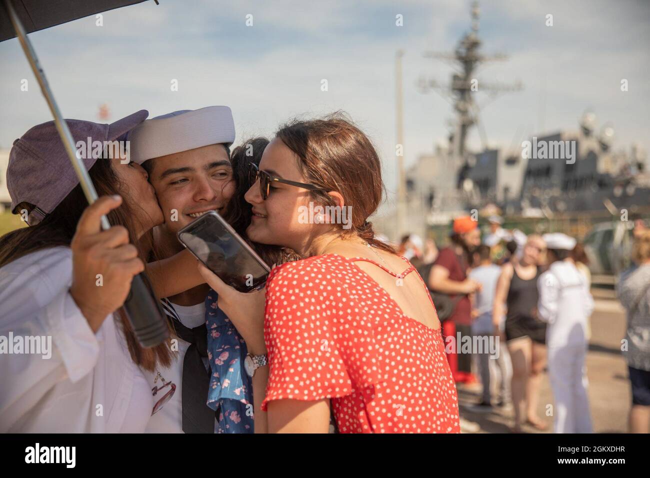 210718-N-GF955-1368 STAZIONE NAVALE MAYPORT, Fl. (18 luglio 2021) – un marinaio assegnato al cacciatorpediniere missilistico guidato di classe Arleigh Burke USS Donald Cook (DDG 75) abbraccia la sua famiglia dopo l’arrivo della nave alla Stazione navale Mayport, Florida. Donald Cook era un cacciatorpediniere Forward schierato Naval Forces-Europe (FDNF-e) alla Stazione Navale di Rota, Spagna per sette anni prima di un trasferimento homeport alla Stazione Navale di Mayport. Foto Stock