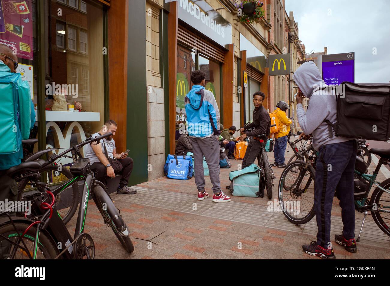 Un certo numero di motociclisti di consegna di fast food si riuniscono fuori da un McDonalds nel centro di Leicester. Foto Stock