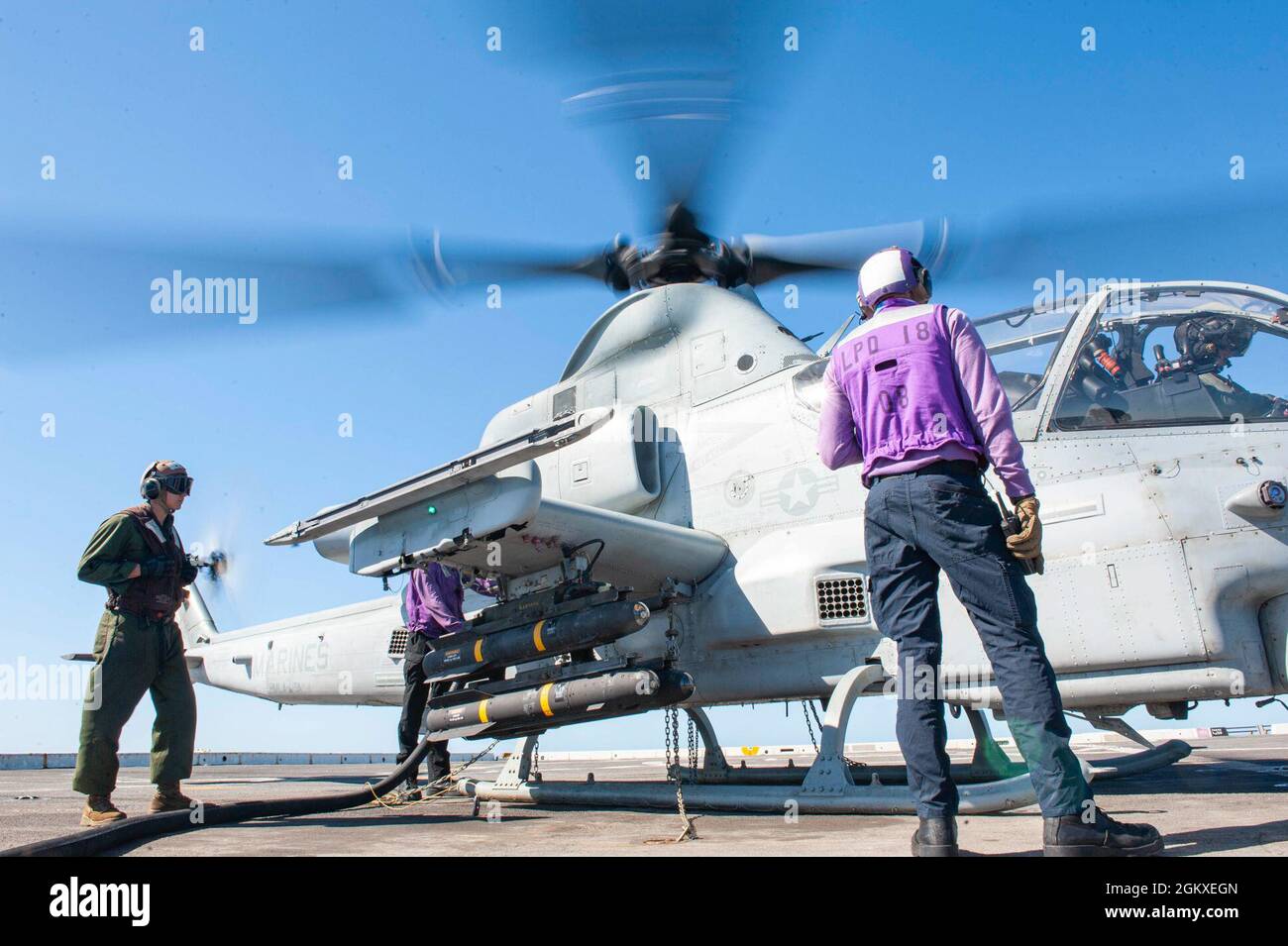 210718-N-XB010-1023 MARE DI CORALLO (18 luglio 2021) marinai assegnati a USS New Orleans (LPD 18) e Marines attaccati alla 31esima unità di spedizione marina (MEU) rifornire un elicottero Cobra del corpo marino degli Stati Uniti AH-1Z sul ponte di volo. New Orleans, parte dell'America Expeditionary Strike Group, insieme al 31° MEU, opera nell'area di responsabilità della settima flotta statunitense per migliorare l'interoperabilità con alleati e partner e fungere da forza di reazione pronta a difendere la pace e la stabilità nella regione indopacifica. Foto Stock