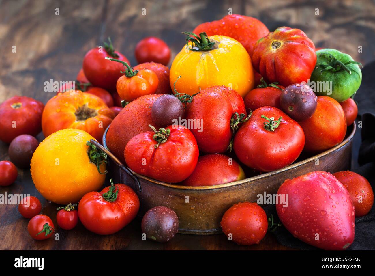 Pomodori freschi maturi rossi e gialli su sfondo rustico Foto Stock