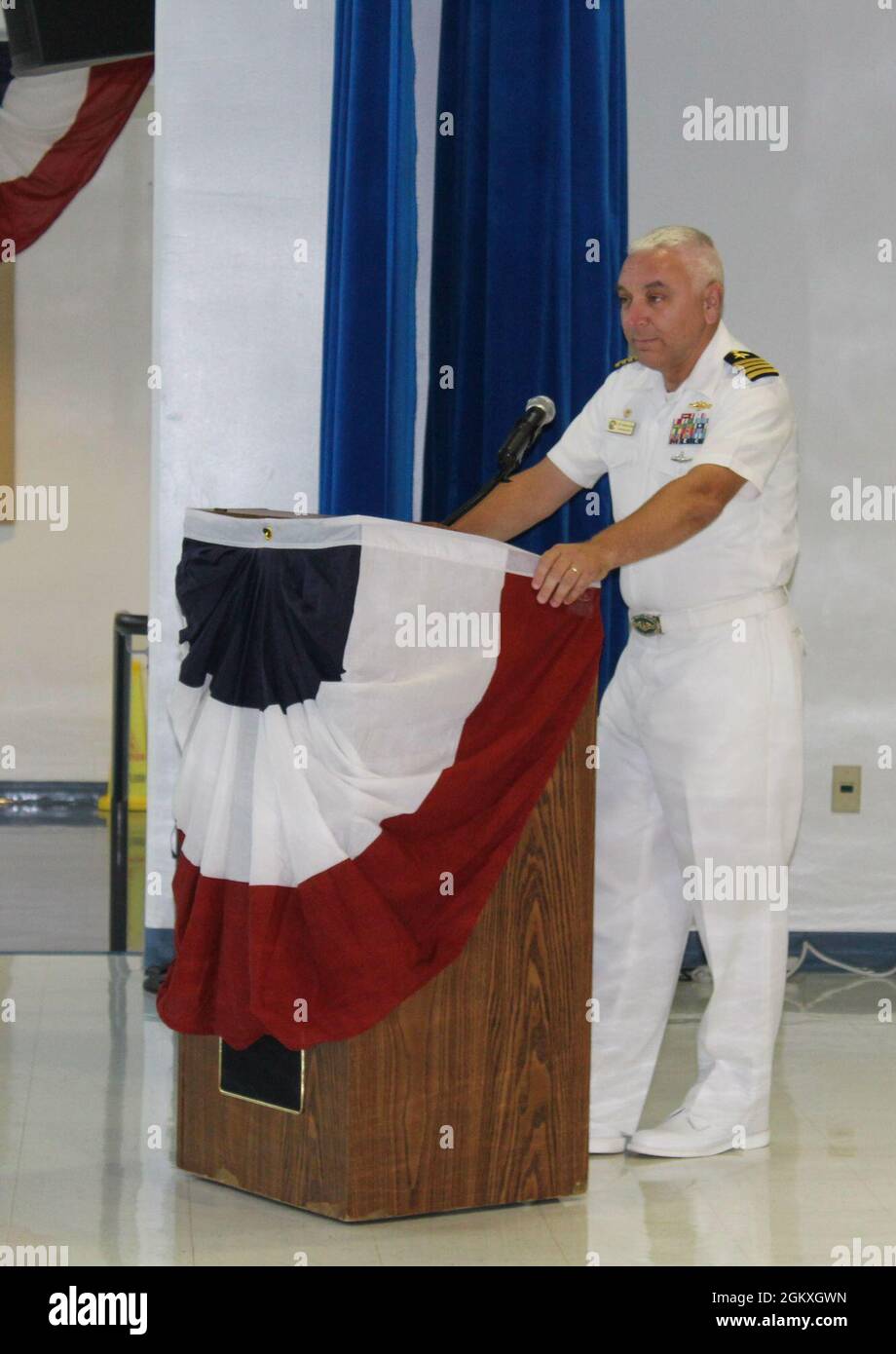 210719-N-VV159-0019.jpg SANTA RITA, Guam (19 luglio 2021) - il Capitano Michael Luckett ha sollevato il Capitano Jeffrey Grimes come ufficiale comandante della base navale statunitense Guam (NBG) durante una cerimonia di cambio di comando tenutasi a CMdR. William C. McCool Scuola elementare/media a bordo di NBG, luglio 19. La cerimonia ha avuto luogo con un numero limitato di ospiti in presenza per garantire le precauzioni di mitigazione COVID-19, ma è stato partecipato virtualmente attraverso il live streaming sui social media. Foto Stock