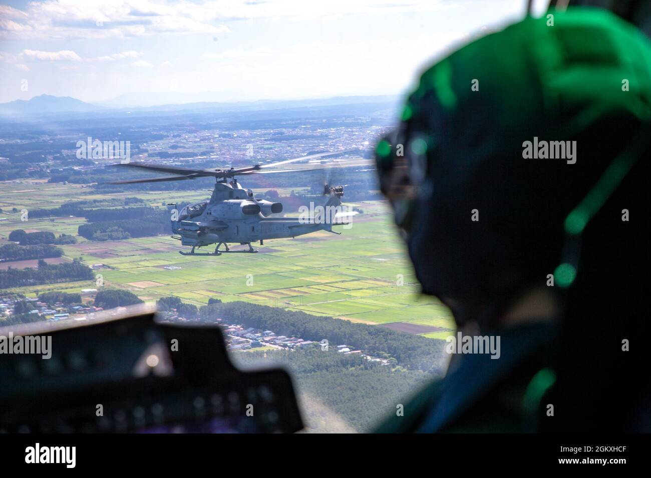 Ryan Stellhorn, un pilota UH-1Y Huey, osserva un viper AH-1Z che vola sopra la prefettura di Aomori, Giappone, 19 luglio 2021. Marine Light Attach Helicopter Squadron (HMLA) 169 ha partecipato a un esercizio di rilocazione di formazione Tiltrotor/Rotary Wing (TR/RW) per integrare le capacità aeree in ambienti poco familiari. Foto Stock