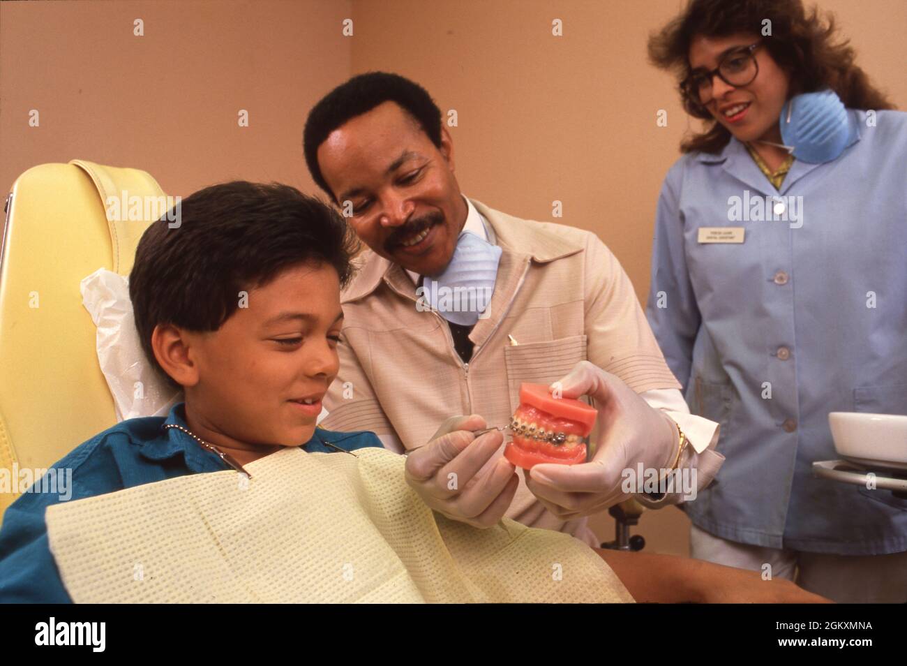 ©1989 Salute dei bambini: Ortodontista e ragazzo ispanico, 7, in clinica. MR XRE-0109, 0110 Foto Stock