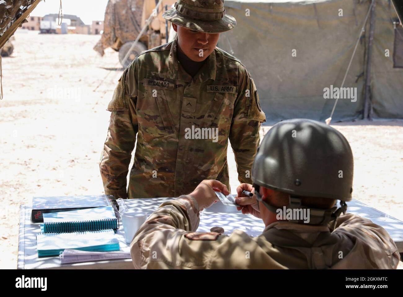 Pvt. Regalado, assegnato a Regimental Support Squadron, 11 Armored Cavalry Regiment, presenta la sua carta di accesso comune per l'ingresso nel campo alimentare sito, National Training Center e Fort Irwin, California, 20 luglio 2021. I soldati nel luogo di alimentazione di campo devono partecipare alle procedure di conteggio di organico prima di entrare nella linea di servizio. Foto Stock