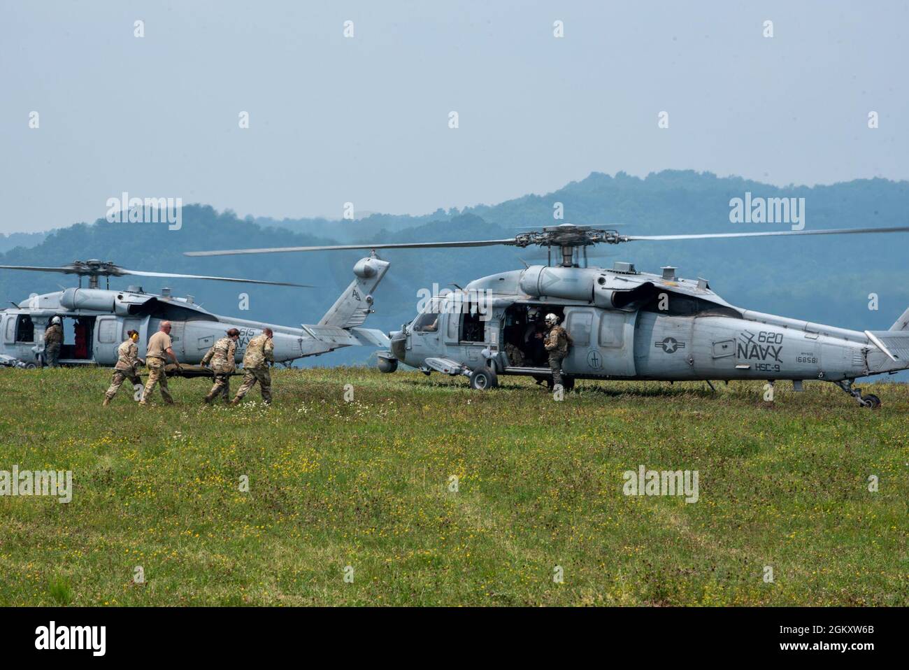 Gli airmen del 167a Squadron di evacuazione Aeromedica, West Virginia Air National Guard, eseguono una missione di evacuazione medica simulata con membri dell'equipaggio navale di Helicopter Sea Combat Squadron Nine, Naval Air Station Norfolk, Virginia, durante Sentry Storm 2021, 21 luglio 2021, a Camp Branch, Logan County, Virginia occidentale. Foto Stock