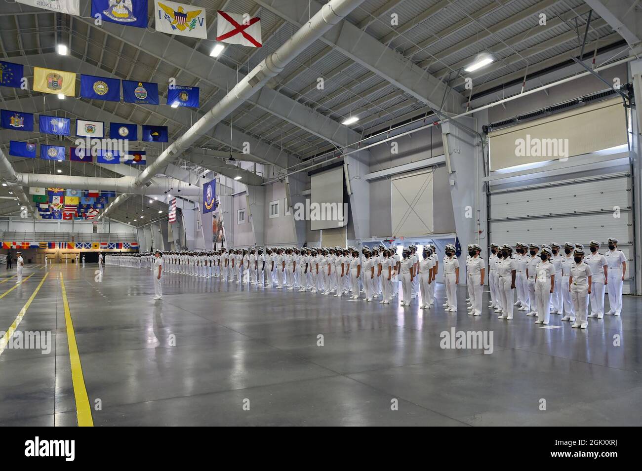 GREAT LAKES, Ill. (22 luglio 2021) – Naval Reserve Officers Training Corps (NROTC) New Student Innoctrination (NSI) i candidati di midshipman si levano in attenzione durante una cerimonia di laurea condotta all'interno della Midway Ceremonial Hall al Recruit Training Command (RTC), luglio 22. I midshipmen inizieranno il loro anno di freschezza del programma NROTC alle università e ai college in tutta la nazione questo autunno. NSI è un programma di indottrinamento di tre settimane ospitato presso la RTC, che fornisce ai midshipmen un orientamento di addestramento militare comune. NSI fornisce un addestramento di base in cinque fondamenti di combattimento di guerra - antincendio, diga Foto Stock