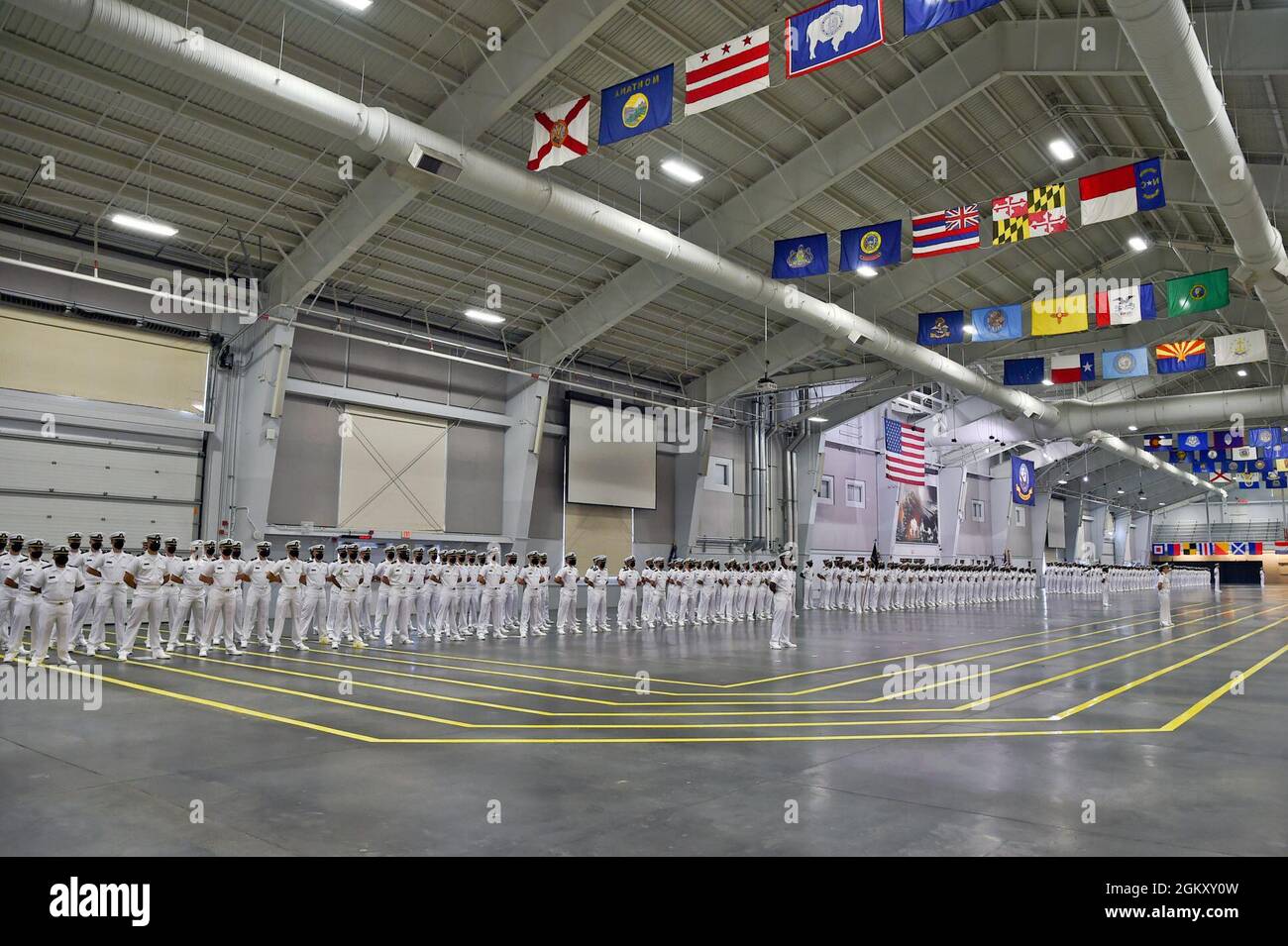 GREAT LAKES, Ill. (22 luglio 2021) – Naval Reserve Officers Training Corps (NROTC) New Student Innoctrination (NSI) i candidati di midshipman si levano in attenzione durante una cerimonia di laurea condotta all'interno della Midway Ceremonial Hall al Recruit Training Command (RTC), luglio 22. I midshipmen inizieranno il loro anno di freschezza del programma NROTC alle università e ai college in tutta la nazione questo autunno. NSI è un programma di indottrinamento di tre settimane ospitato presso la RTC, che fornisce ai midshipmen un orientamento di addestramento militare comune. NSI fornisce un addestramento di base in cinque fondamenti di combattimento di guerra - antincendio, diga Foto Stock