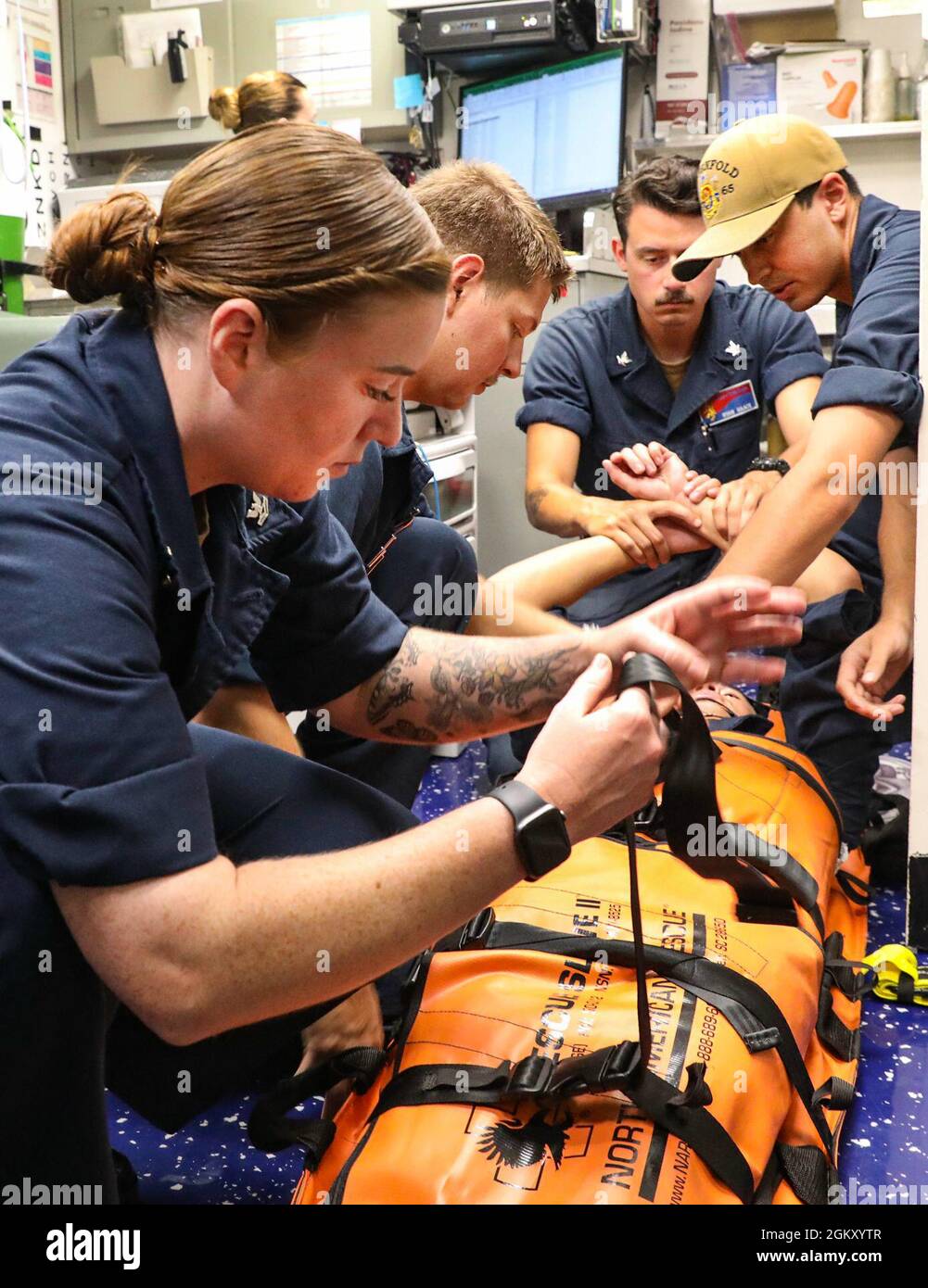 I marinai a bordo del cacciatorpediniere missilistico guidato di classe Arleigh Burke USS Benfold (DDG 65) conducono un addestramento avanzato del portatore della barella. Benfold è assegnato al Comandante, Task Force (CTF) 71/Destroyer Squadron (DESRON) 15, il più grande DESRON dispiegato in avanti della Marina e la principale forza di superficie della 7a flotta statunitense. Foto Stock