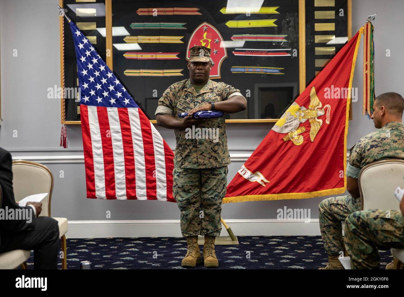 Gunnery Sgt. Anthony Brown, nativo di Houston e ex capo della mobilità della 22a Marine Expeditionary Unit, si erge con “Old Glory” durante la sua cerimonia di pensionamento a bordo del Marine Corps base Camp Lejeune, 22 luglio 2021. Brown si ritirò dopo 20 anni di servizio attivo. Foto Stock