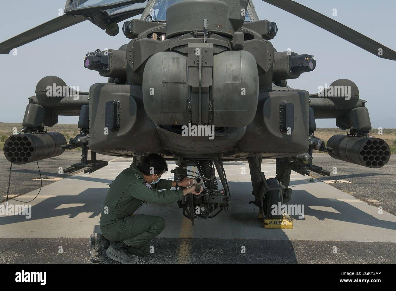 Dopo che il team di manutenzione dell'equipaggio di terra ha effettuato i controlli in preflight, i piloti Apache AH-64 si sono aggirati intorno all'aeromobile effettuando i controlli. Il centro di addestramento per il combattimento a Orchard della Guardia Nazionale dell'Esercito dell'Idaho è stato ospite di elementi dell'Aeronautica militare della Repubblica di Singapore nel mese di luglio. Con sede in Arizona, il contingente di Singapore gestisce otto elicotteri Apache AH-64 come parte della Peace Vanguard Task Force. Apache è un elicottero da attacco con un cockpit tandem per un equipaggio di due. È dotato di un sensore montato sul naso per l'acquisizione del bersaglio e i sistemi di visione notturna. È dotato di un braccio di 30 mm Foto Stock