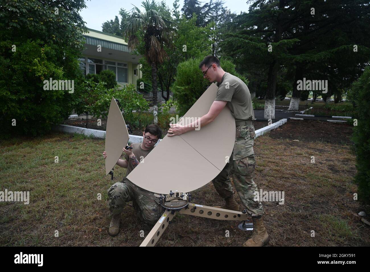 U.S. Air Force staff Sgt, Brenden Lowe, 1st Combat Communications Squadron radio frequency transmission Systems Supervisor, left, and Airman First Class Isaac Peebles, 1st CBCS radio frequency transmission Systems, Build a tattical satellite during Exercise Agile Spirit 21 at Tbilisi, Georgia, 25 luglio 2021. Lowe e Peebles costruì il satellite tattico per comunicare con le forze aeree statunitensi che orbitano nella zona. Questa infrastruttura di comunicazione consente ad alleati e partner di comunicare in modo rapido ed efficace durante Agile Spirit 21. L'esercizio promuove la stabilità regionale Foto Stock