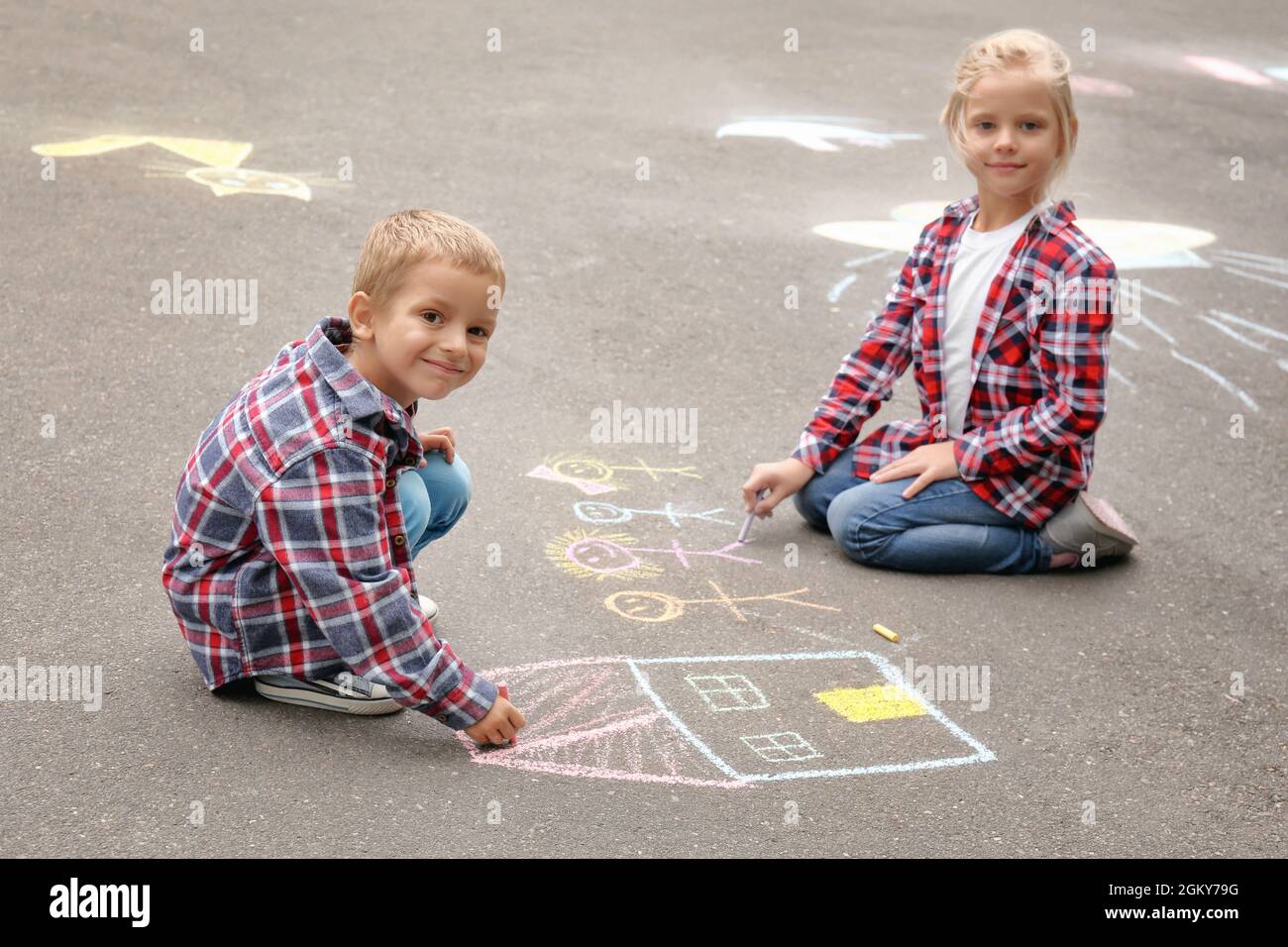 Bambini piccoli disegnando casa e famiglia con gesso su asfalto Foto stock  - Alamy