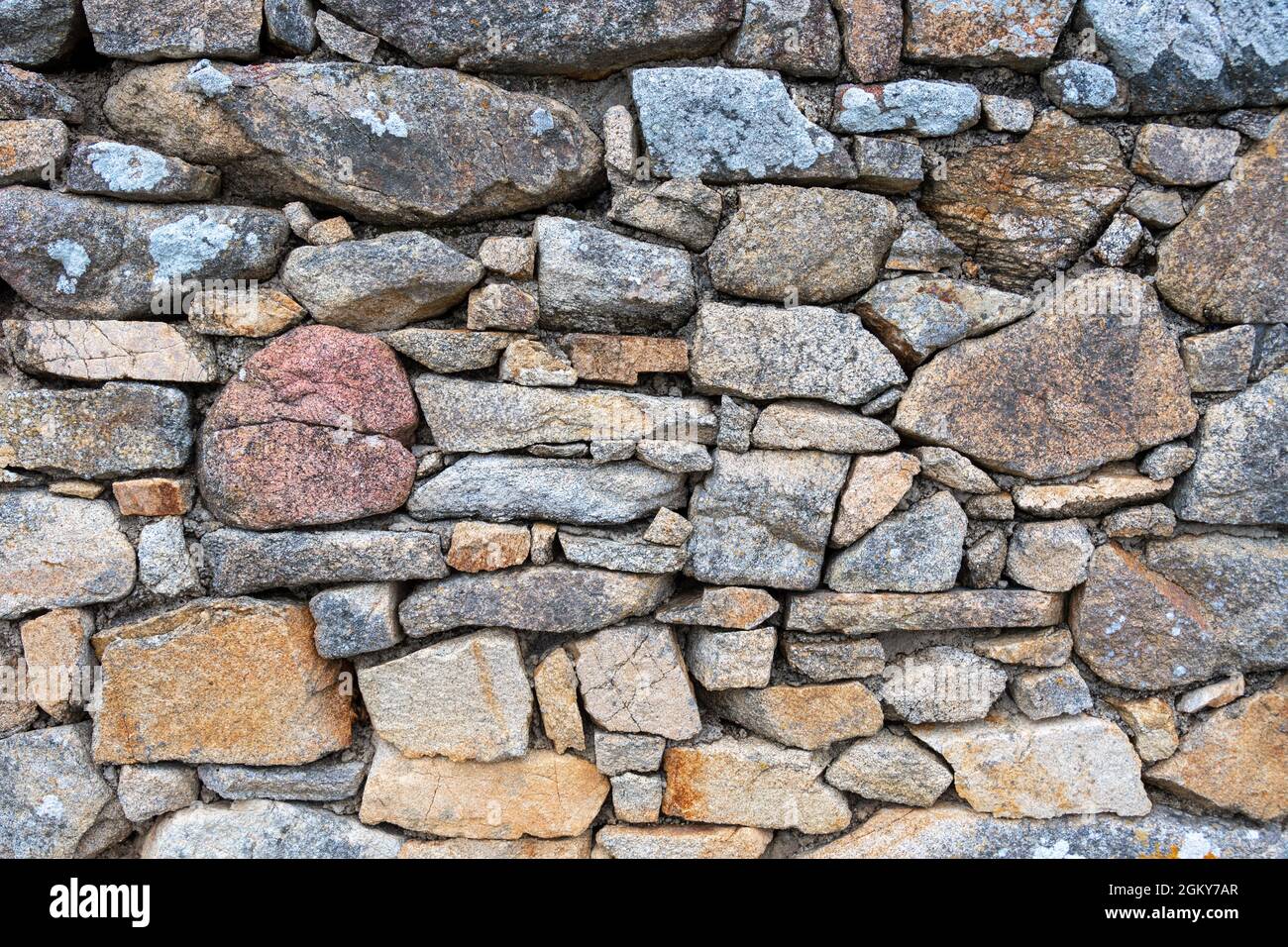 Particolare di un muro di pietre irregolari e colorate in Bretagna, Francia Foto Stock