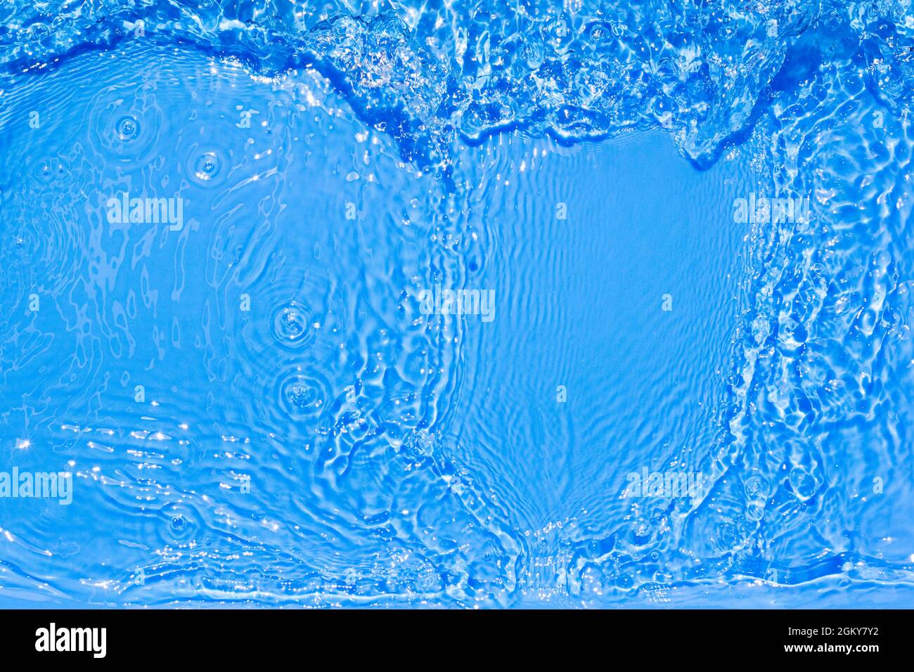 Superficie di acqua di piscina blu con riflesso chiaro. Trama di acqua blu trasparente con ondate e ondulazioni in piscina. Astratto alla moda Foto Stock