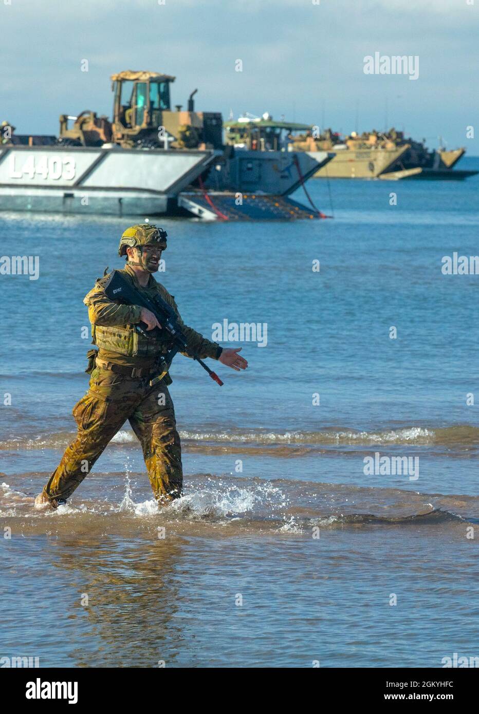 Un soldato con l'Esercito Australiano guida un portatore di personale corazzato da un'imbarcazione di atterraggio alla riva vicino alla città di Ingham durante l'esercizio Talisman Sabre 2021. Questa è la nona iterazione di Talisman Sabre, un'esercitazione militare bilaterale su larga scala tra l'Australia e gli Stati Uniti che coinvolge più di 17,000 partecipanti da sette nazioni. L'esercitazione multidominio di un mese consiste in una serie di eventi formativi che rafforzano la forte alleanza tra Stati Uniti e Australia e dimostrano l'impegno costante dell'esercito statunitense verso un libero e aperto Indo-Pacific. Foto Stock