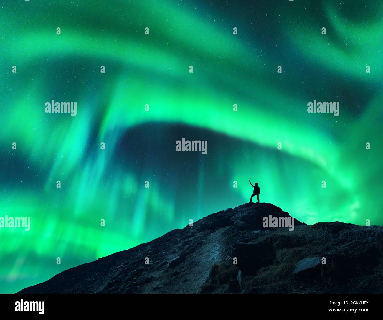 Aurora boreale e silhouette di donna con braccia rialzate Foto Stock